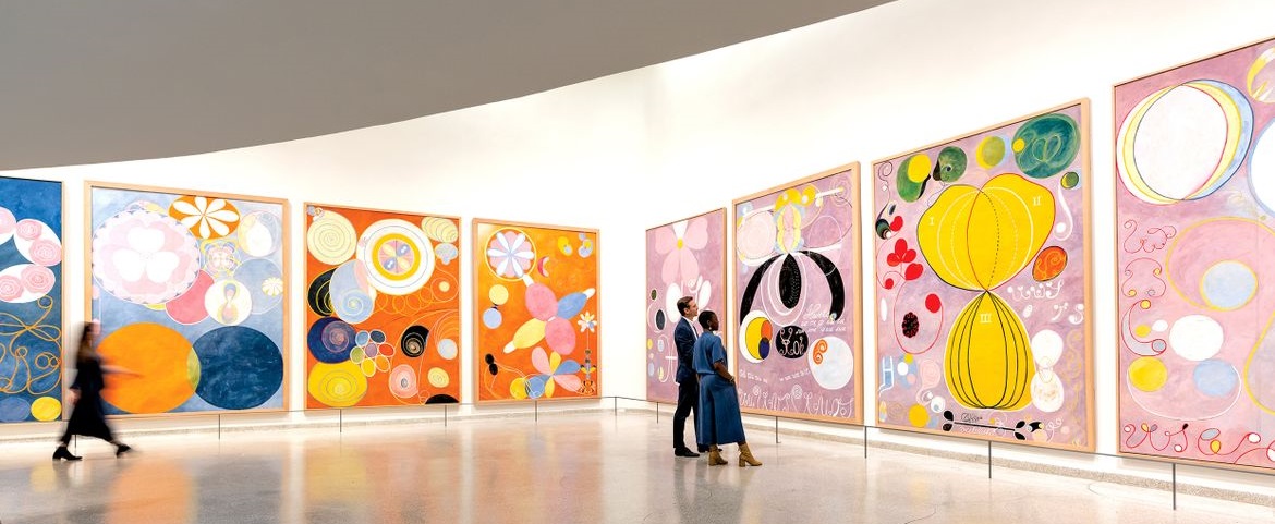 Museum interior with colorful paintings on the white walls